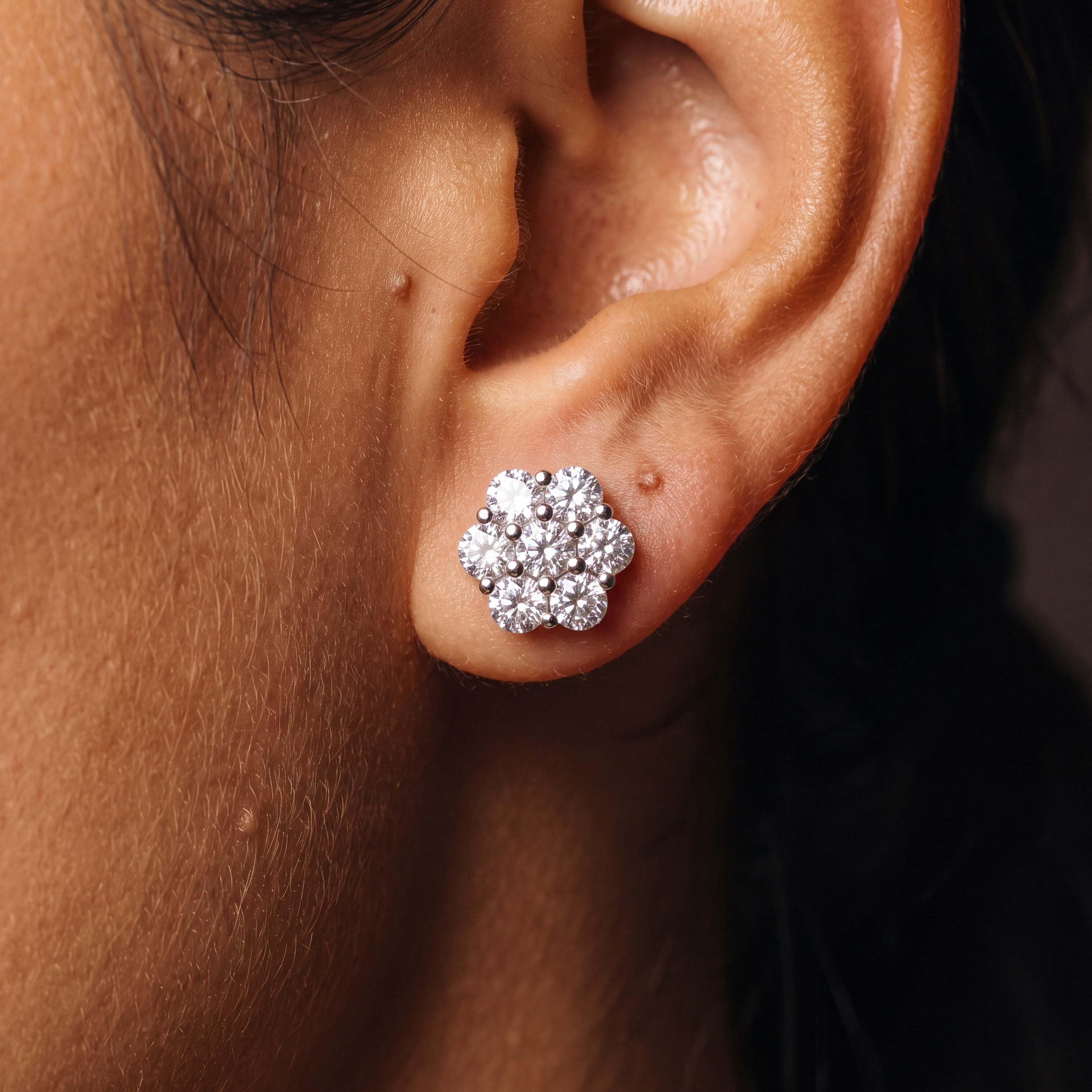 Moissanite flower cluster stud earring seen from a second angle on the earlobe